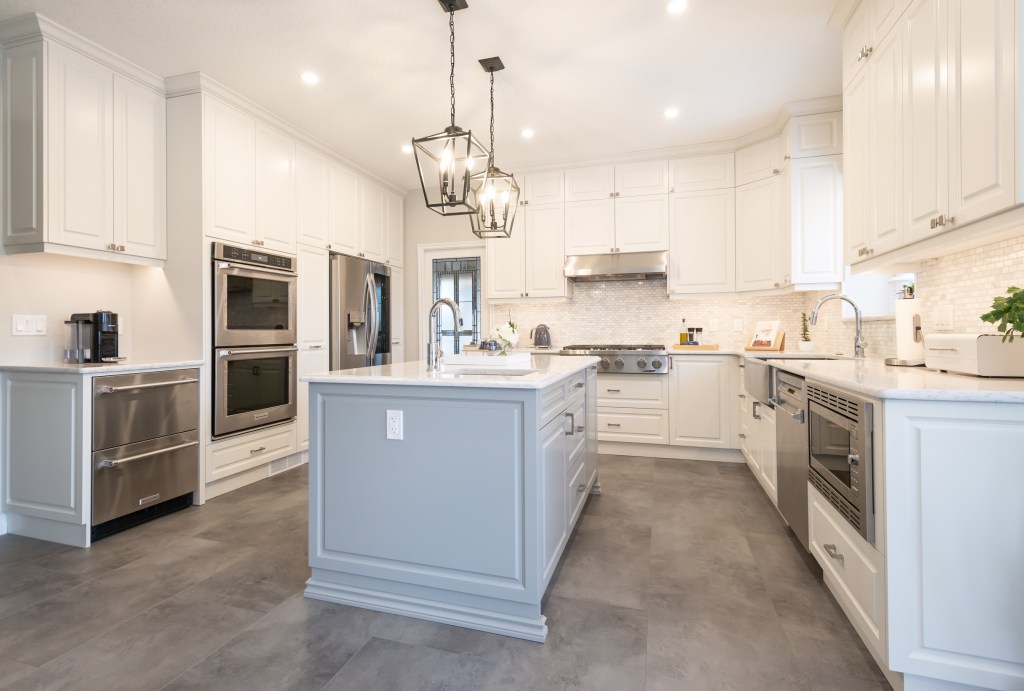 Beautiful Kitchen Renovation in Edmonton, with painted maple cabinets, quartz countertops and tile flooring.  This kitchen renovation was part of a whole main floor renovation and update that was completed by Awlridge Renovations.
